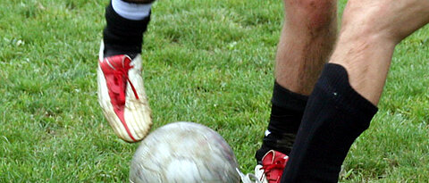 Zwei Fußballer kämpfen um den Ball.