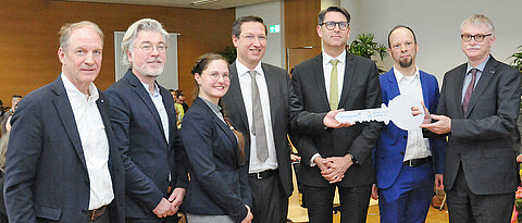 Handing over the keys for the opening of the DZPP with (from left) Thomas Jansing (Sternstunden), Tobias Bansen and Franziska Klemm (KKH), Marcel Romanos (DZPP), Tim J. von Oertzen (UKW), Arne Bürger (DZPP) and Uwe Klug (JMU).