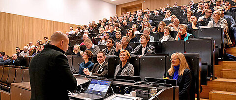 Roland Baumann, Koordinator für digitale Bildung, begrüßt die Tagungsteilnehmer. In der ersten Reihe: Monika Zeyer-Müller (2. v.r.) und Silke Grafe (1. v.r.) (Bild: Anne Thees)