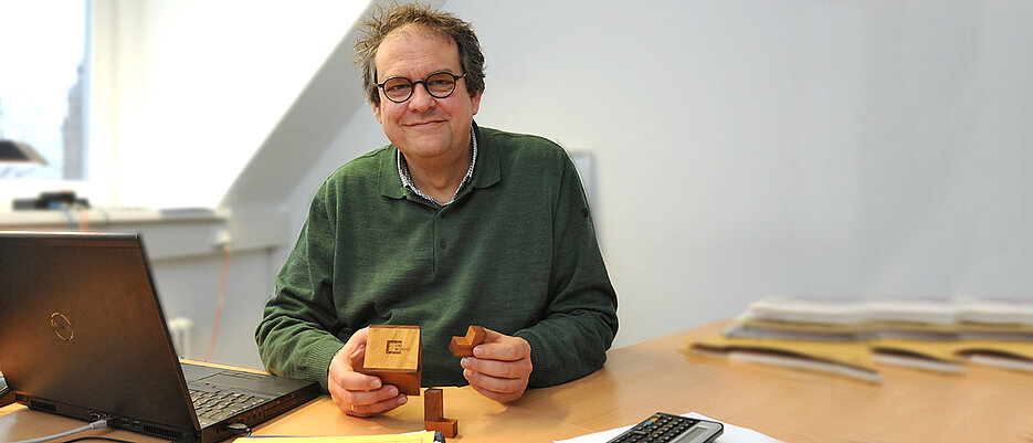 Volker Latussek mit dem Würfel der Universität Würzburg. 