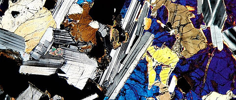 Der Blick durch das Mikroskop zeigt die Minerale des Gesteins Gabbro in ihren typischen Interferenzfarben. Wer mehr darüber wissen möchte, erfährt dies bei einem Besuch im Mineralogischen Museum.