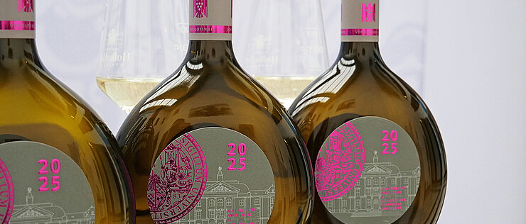 Three bottles of UniWein stand in a row on a table.