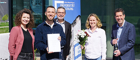 Federico Ronchetti (2.v.l.) bei der Übergabe seiner Dissertation an die Sachbearbeiterin der GSLS, Eva Dallmann (links). Es gratulieren (v.l.) Dr. Stephan Schröder-Köhne (Geschäftsführer der Graduiertenschulen der Universität Würzburg), Dr. Jennifer Ritzer (Geschäftsführerin der GSLS) und Professor Christian Wegener (Direktor der GSLS). 