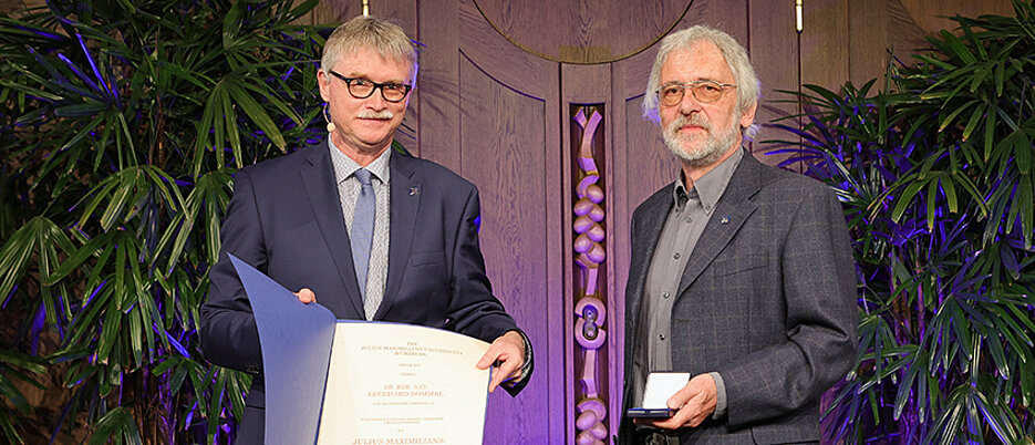 Eberhard Rommel (rechts) wurde auf dem Stiftungsfest 2022 mit der Julius-Maximilians-Verdienstmedaille ausgezeichnet. Ihm gratulierte Kanzler Uwe Klug.