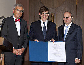 Verleihung der Ehrendoktorwürde an Otmar D. Wiestler (Mitte). Links: Dekan Matthias Frosch, rechts Laudator Hermann Einsele. (Foto: Angie Wolf)