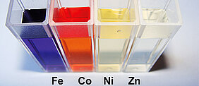 Vier Reagenzgläser, die unterschiedlich gefärbte Flüssigkeiten enthalten.