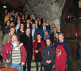 Gruppenbild der neuen Professorinnen und Professoren auf einer Treppe im Staatlichen Hofkeller. In der ersten Reihe von rechts nach links: Jochen Gummersbach vom Hofkeller,  Hanna Kounev vom Welcome Center der Uni,  Bürgermeisterin Marion Schäfer-Blake 