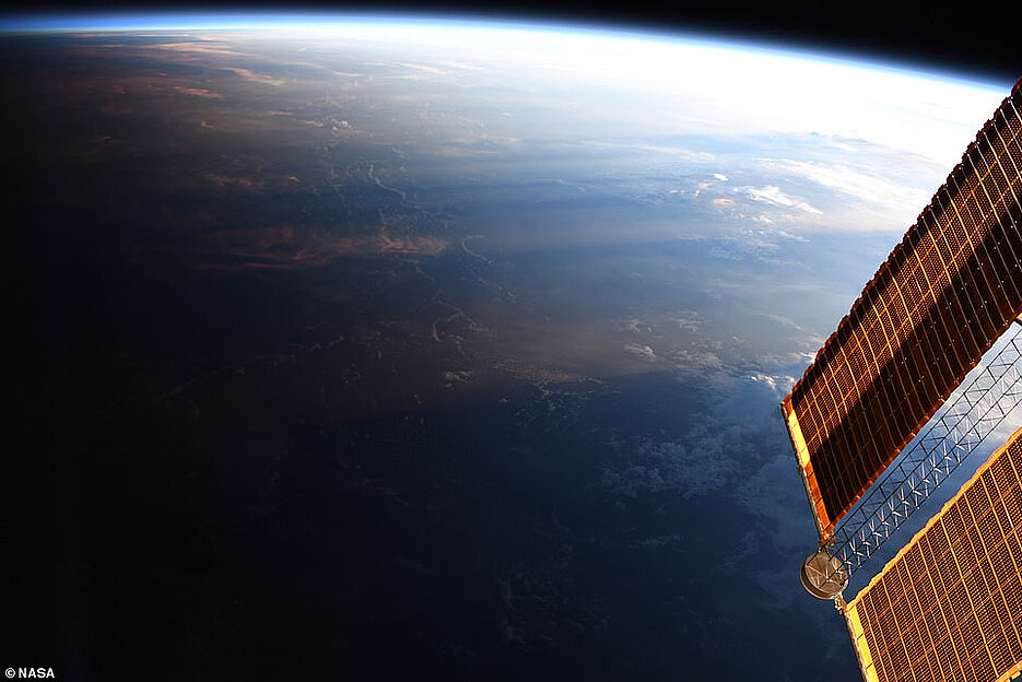 Der Tag wird zur Nacht, aufgenommen von der ISS. Deutlich zu sehen ist die dünne Erdatmosphäre mit einer Dicke von gerade einmal 1,57 Prozent des Erdradius‘.