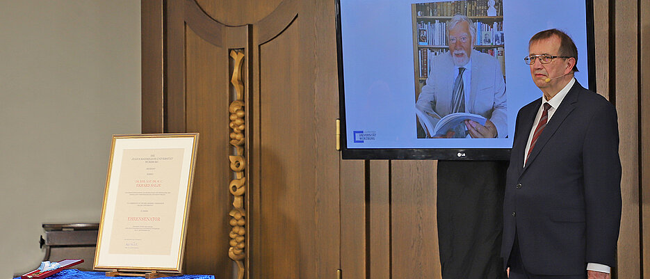 Ekhard Salje konnte bei seiner Ernennung zum Ehrensenator nicht anwesend sein. Das Foto zeigt JMU-Präsident Alfred Forchel mit einem Foto des Geehrten.
