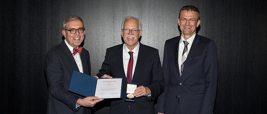 Joachim Fuchs (Mitte) bei seiner Ehrung. Links Matthias Frosch, Dekan der Medizinischen Fakultät, rechts Jens Maschmann, Ärztlicher Direktor des Universitätsklinikums.