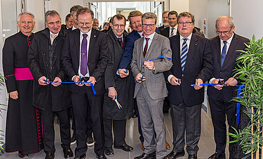 Eröffnet wurde das neue Institutsgebäude der Anorganischen Chemie mit dem Durchschneiden eines blauen Bandes. Vorn in der Mitte (ab 3.v.l.) Professor Holger Braunschweig, Unipräsident Alfred Forchel, Uni-Vizekanzler Klaus Baumann und Minister Bernd Sibler.