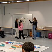 Eine Studentin erarbeitet mit den Schüler:innen den Aufbau eines Klimadiagramms.