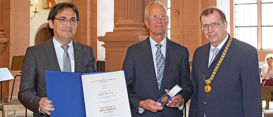 Nach der Verleihung der Verdienstmedaille: Gerd Müller mit Laudator Univizepräsident Baris Kabak (l.) und Unipräsident Alfred Forchel (r.)