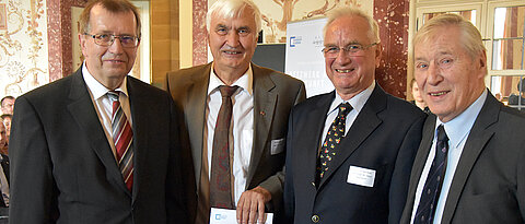 Theodor Berchem, Vorsitzender des zentralen Alumni-Vereins (rechts), und Universitätspräsident Alfred Forchel (links) gratulieren Peter Rost und Claus Naumann, die ihr Medizinstudium vor 50 Jahren beendeten.