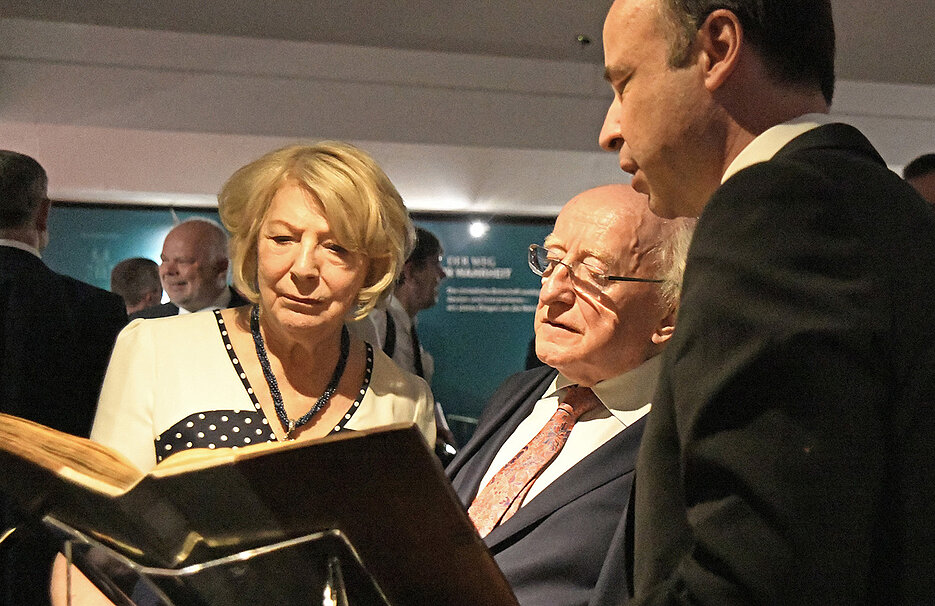 Der irische Staatspräsident Michael D. Higgins und seine Frau Sabina bewundern irische Schätze in der Universitätsbibliothek. Rechts deren Direktor Hans-Günter Schmidt.