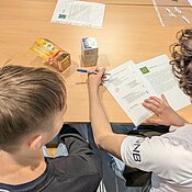 Die Schüler untersuchen die verschiedenen Siegel auf der Teeverpackung.
