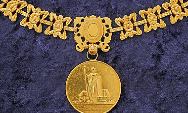 Die Göttin Athena ist auf der Rückseite der Medaille abgebildet. Die Inschrift lautet „Universitas Iulio-Maximilianea MDCCCXXXIV“.