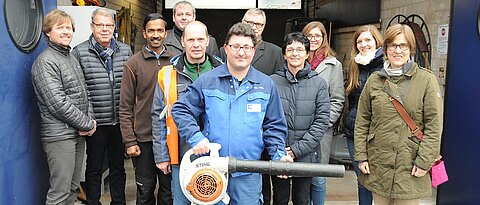 Christoph Nölke zeigte Vertreterinnen der Mainfränkischen Werkstätten und Mitarbeitern der Universität den Laubbläser und andere Geräte, mit denen sein Team auf dem Hubland-Campus unterwegs ist. (Foto: Robert Emmerich)