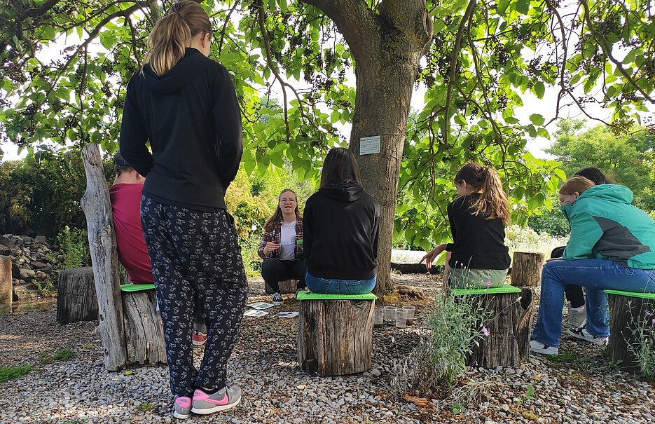 Schüler:innen stapeln Becher mit Kies, Sand, Erde und Kaffeefilter übereinander und übergießen diese mit Wasser. Schüler:innen stapeln Becher mit Kies, Sand, Erde und Kaffeefilter übereinander und übergießen diese mit Wasser.