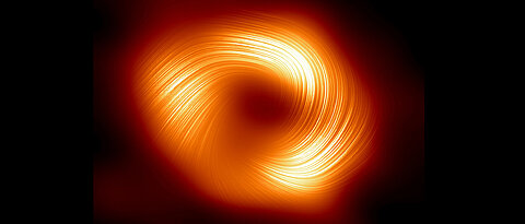 Polarisierter Blick auf Sagittarius A*, das Schwarze Loch im Zentrum der Milchstraße. Die Linien markieren die Ausrichtung der Polarisation, die mit dem Magnetfeld um den Schatten des Schwarzen Lochs zusammenhängt.
