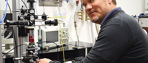 An diesem Mikroskop im Magnetresonanz-Labor „kommuniziert“ Hannes Kraus mit Defekten im Siliziumkarbidkristall. (Foto: Uni Würzburg)