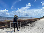 Professorin Laura Otto an einem Strand in Mexiko, der von Algen bedeckt ist. Sie hat eine Maske auf, weil die Algen stinken. (Foto: Laura Otto)