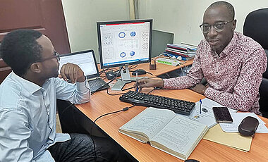 Jules Tshishimbi (rechts) mit dem Studenten Bienfait Isamura, ebenfalls BEBUC-Stipendiat, bei der Diskussion über eine in seiner Gruppe entwickelte neue Methode für die Theoretische Chemie.