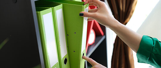Woman take documents in folders in archive closeup. Working with documentation concept