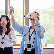 Antonia Halsch testet die VR-Brille. Oyudari Vova steht nebendran. 