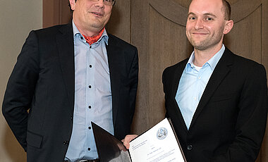 Mathias Lutz (r.) wurde mit dem Preis aus dem Nachlass von Klug und Sichler für seine Arbeit über die Immunität gegen Tumorantigene ausgezeichnet. Links im Bild: Laudator Peter Heuschmann. (Bild: Angie Wolf) 