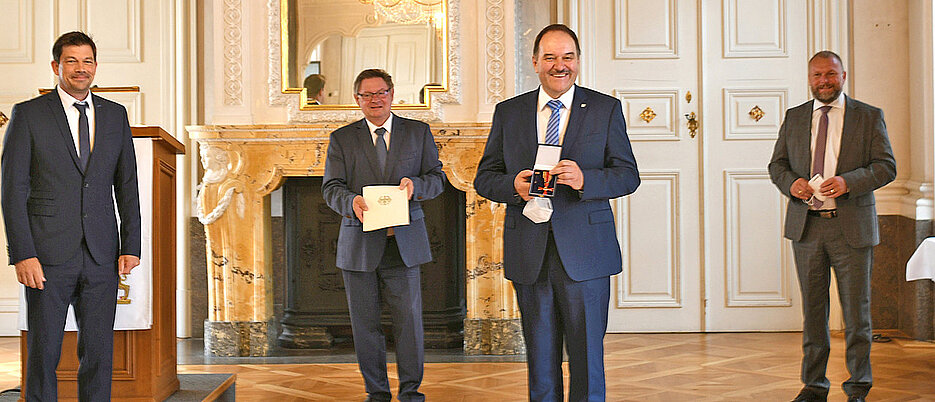 Gerhard Sextl (2.v.r.) mit dem frisch verliehenen Bundesverdienstkreuz. Ihm gratulieren (v.l.): Alexander Knahn, 1. Bürgermeister von Höchberg, Staatssekretär Gerhard Eck und Landrat Thomas Eberth. (Bild: Fraunhofer ISC) 