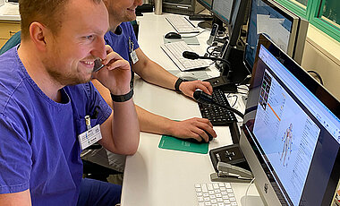 Im Kontrollraum beobachten die Instruktoren Quirin Zednik (vorne) und Felix Gardill die Abläufe der Simulation und dokumentieren deren Schlüsselmomente für die Nachbesprechung.
