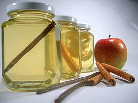 Honiggläser mit verschiedenen Zutaten: Vanille, Zimt, Apfel