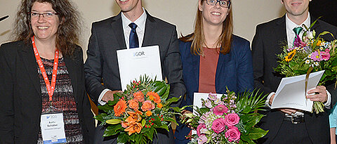 Benedikt Schulte (2.v.l.) bei der Verleihung des Dissertationspreises in Hamburg. Gleichzeitig wurden Elisabeth Lübbecke (Berlin) und Andreas Bärmann (Erlangen-Nürnberg) ausgezeichnet. Links Professorin Anita Schöbel, Vorsitzende der Jury. (Foto: GOR)