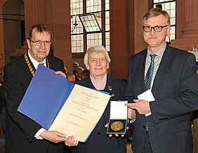 Traute Schroeder-Kurth bekommt von Universitätspräsident Alfred Forchel (links) und Kanzler Uwe Klug die Röntgenmedaille überreicht. (Foto: Robert Emmerich)
