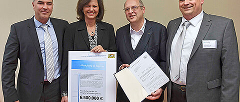 Bei der Übergabe des Förderbescheids (von links): Peter Jakob, Ilse Aigner, Randolf Hanke und Karl-Heinz Hiller. (Foto: Fraunhofer IIS/Peter Roggenthin)