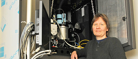 Prof. Dr. Bettina Böttcher in front of Titan Krios, one of the world's most powerful electron microscopes (photo: Gunnar Bartsch)