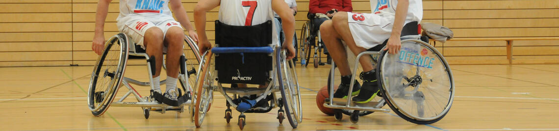 Chancengleichheit an der JMU Würzburg – drei Studierende spielen zusammen Rollstuhlbasketball