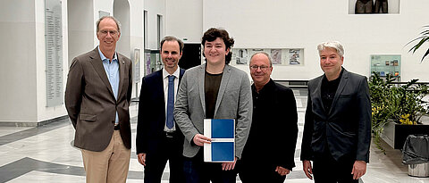 Frühstudent Veit Lang (Mitte) bekam von JMU-Präsident Paul Pauli (links) Unterlagen überreicht, die die Anrechnung seiner Leistungen ermöglichen. Mit im Bild: Markus Binzenhöfer (Zweiter v.li.), Richard Greiner (Zweiter v.re.) und Tobias Richter (re.).
