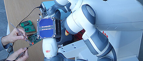 Der Leichtbau-Roboter-Arm hält während der Satelliten-Integration die Platinen. (Foto: Zentrum für Telematik).