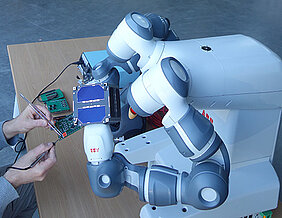Der Leichtbau-Roboter-Arm hält während der Satelliten-Integration die Platinen. (Foto: Zentrum für Telematik).