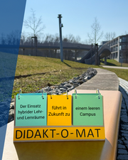 Aufsteller mit Text "Der Einsatz hybrider Lehr- und Lernräume führt in Zukunft zu einem leeren Campus" steht auf einer Bank vor einer großen Brücke am Campus Hubland.