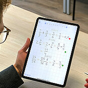 Ein Schüler bearbeitet am Tablet Rechenaufgaben mit der App Living-Lines.