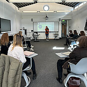 Workshoprunde zu Vilearn. Melanie Hartmann referiert, die Teilnehmenden hören zu.