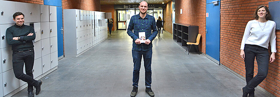 Sie sind für die Aktion „Eine Uni - ein Buch“ an der Uni Würzburg verantwortlich (v.l.): Michael Storch, Julien Bobineau (mit dem Buch „Was ist Populismus?“ in der Hand) und Christine Ott. Es fehlt: Kristina Helmerich. (Foto Sven Staffeldt)