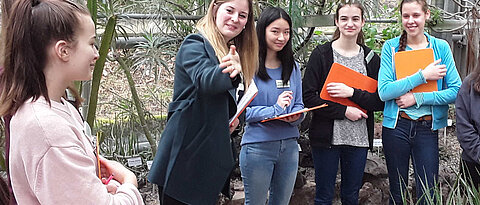 Studentin zeigt Schülerinnen Wolfsmilchgewächse und Aloen im Xerophythenhaus