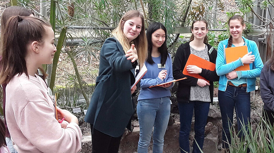 Studentin zeigt Schülerinnen Wolfsmilchgewächse und Aloen im Xerophythenhaus