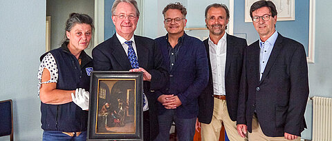 Joachim Spatz, Andreas Götz und Jan Röhrle von der Freimaurerloge „Zu den zwei Säulen an der festen Burg“ bei der Rückgabe des Gemäldes im Logenhaus. Mit im Bild: Restauratorin Ingeborg Klinger (1. v. l.) und Damian Dombrowski (3. v. l.), Direktor der Neueren Abteilung des Martin von Wagner Museums. 