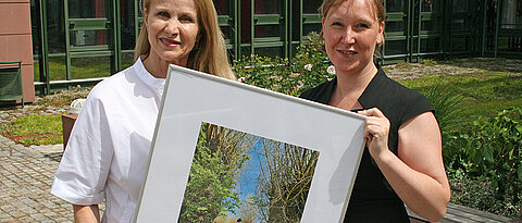 Preisträgerin Pia Bayer (r.) mit ihrem preisgekrönten Foto und Uni-Pressesprecherin Esther Knemeyer bei der Preisverleihung. 