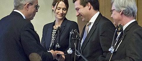 Dekan Matthias Frosch (links) überreicht den Lehrpreis an Katharina Domschke, Marcel Romanos und Jürgen Deckert. (Foto: Patrick Geißler)